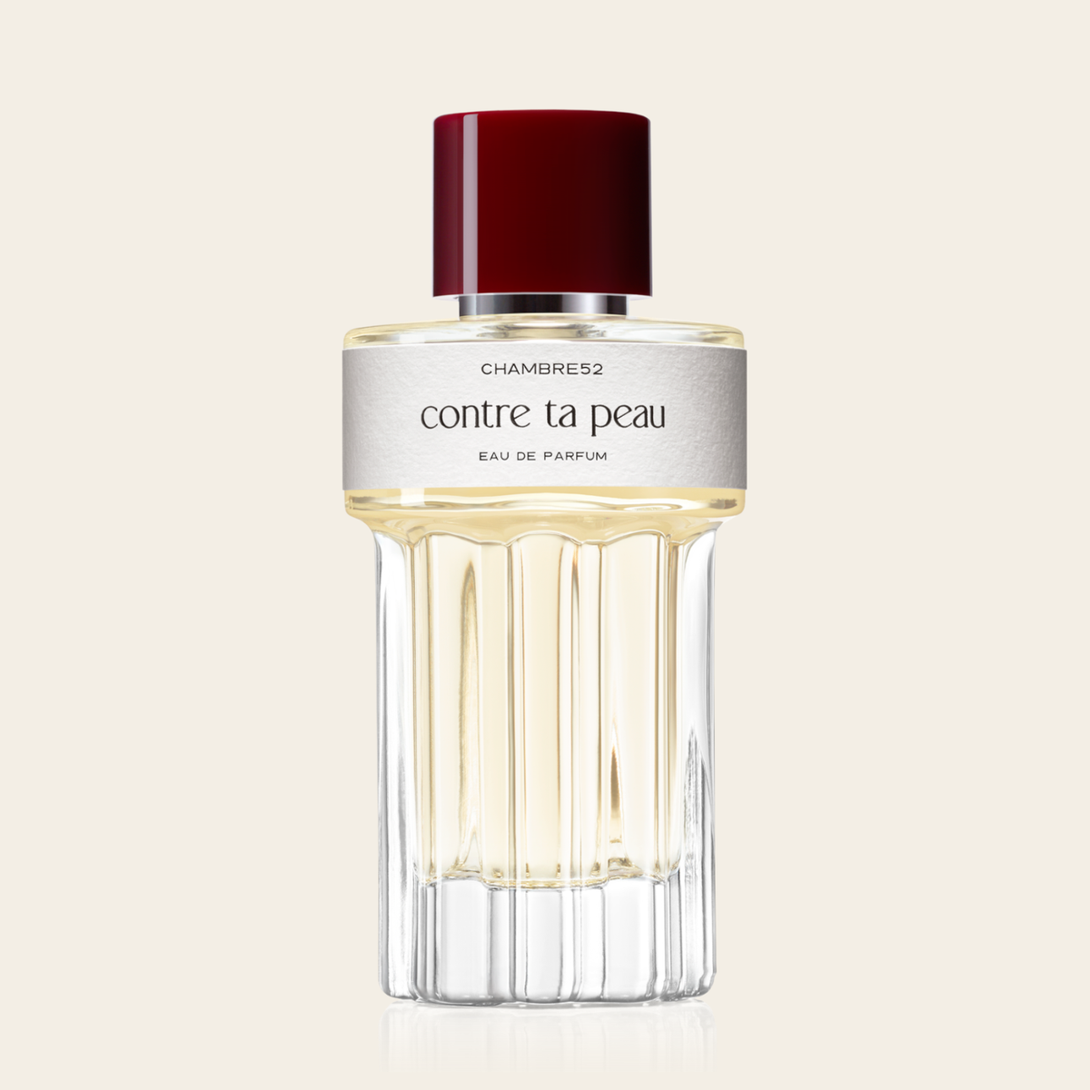 100ml Flakon von Contre ta Peau von Chambre52 – rundes Glasflakon mit bordeauxrotem Verschluss und cremeweißem Etikett.