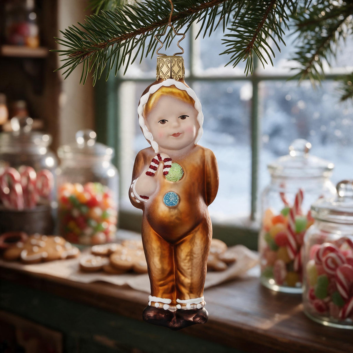 Inge Glas ornament “Sweet Tooth”, 12 cm, on a fir sprig in a nostalgic sweet shop with jars of sweets, candy canes and gingerbread in front of the snowy shop window – scene image created with AI, product shown as original.